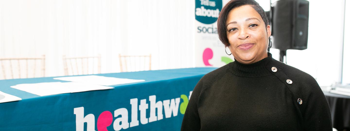Lady standing in front of a Healthwatch banner