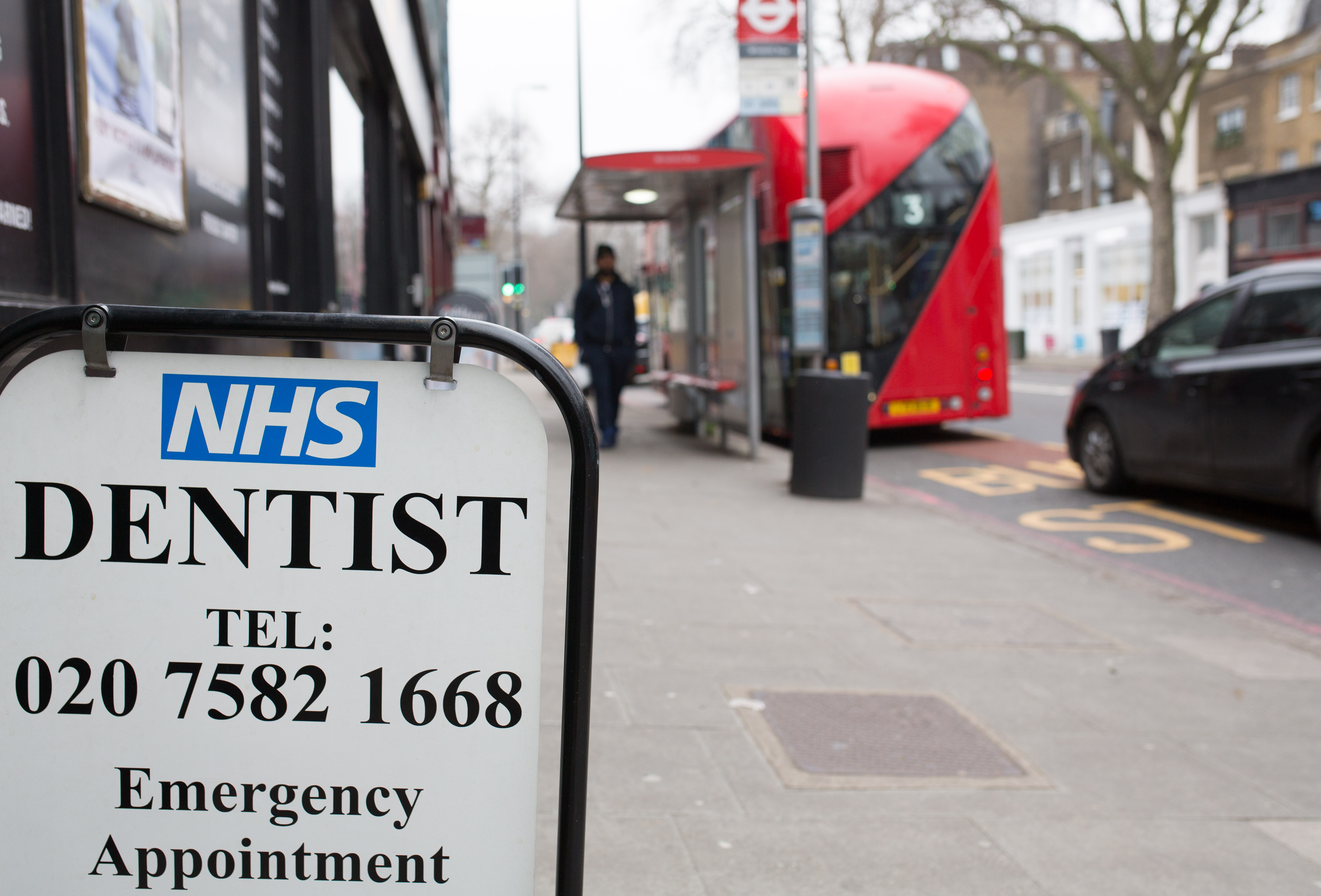 A sign on the street giving information about dentist