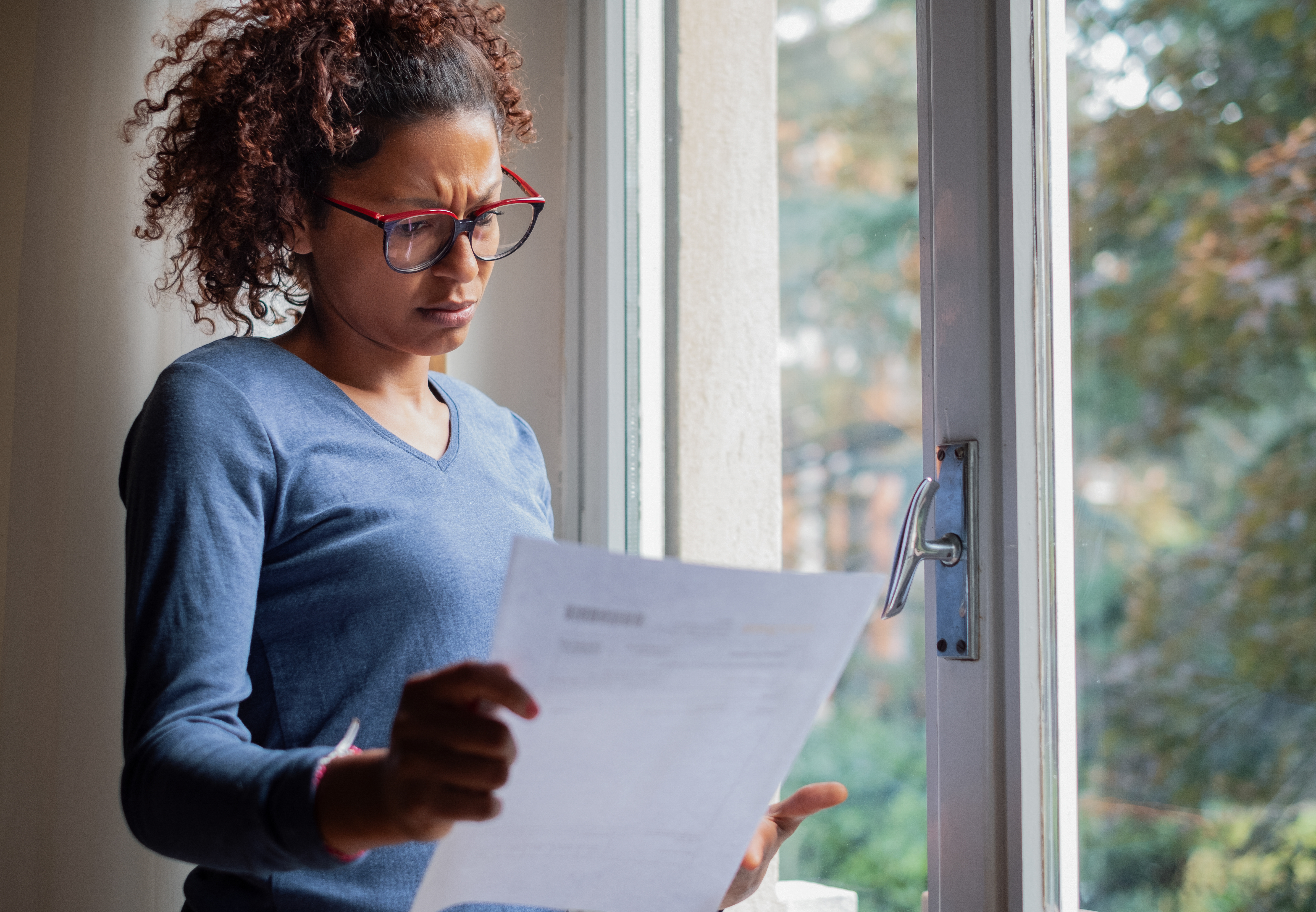 Lady holding a letter looking confused