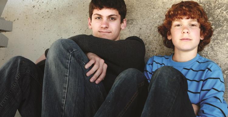 Two boys sitting down outside