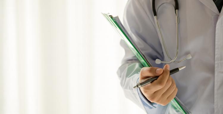 Male doctor with clipboard, pen and stethoscope 