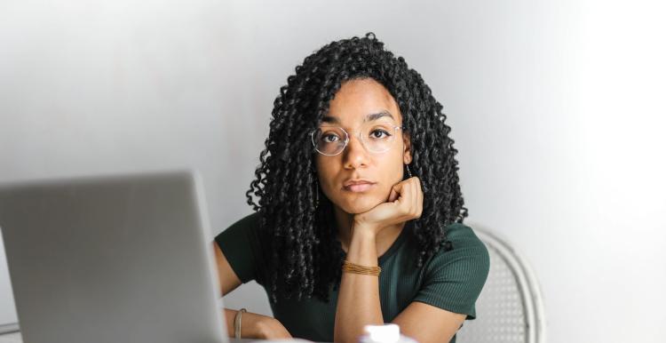A lady sitting at her desk thinking about writing an email about her NHS complaint 