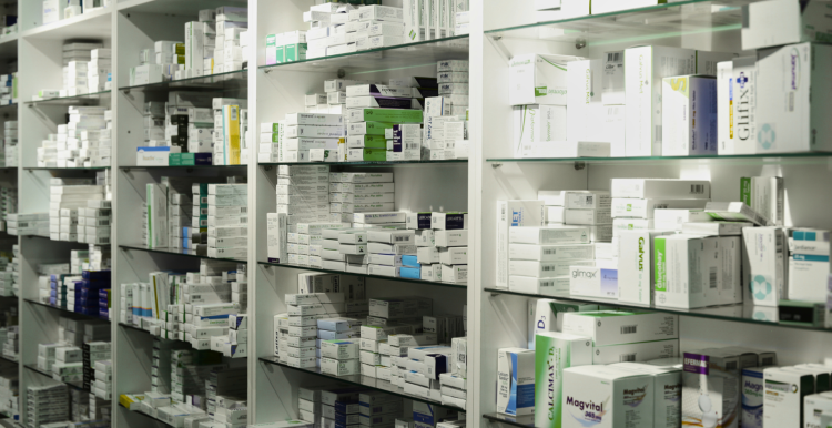 NHS prescription charges, image of medicine packs on a shelf inside a pharmacy