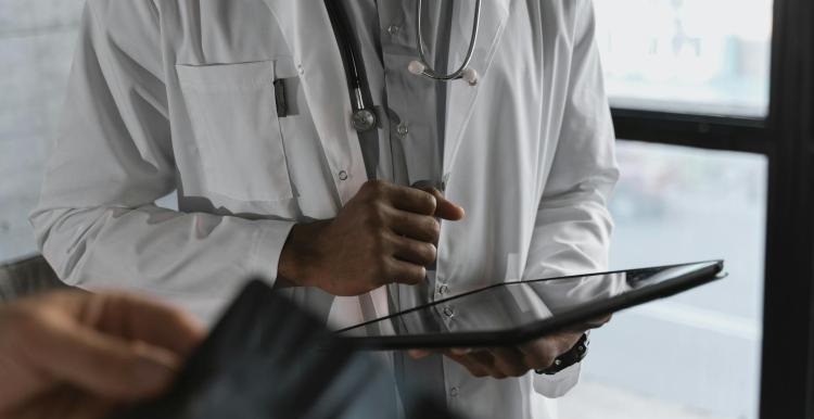 Doctor completing an online document on a tablet