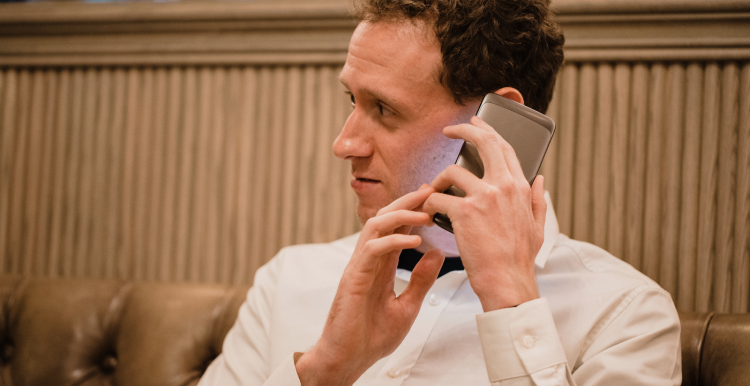 A close-up of a man who has his smartphone in his hand and he is using a visually impaired mobile app to help assist him.