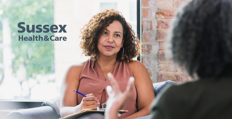 Two ladies sitting on a sofa talking about their mental health