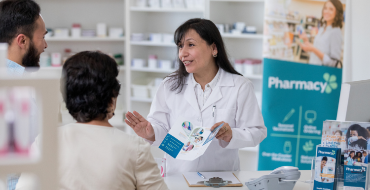 A pharmacist talking to a male and female patient 