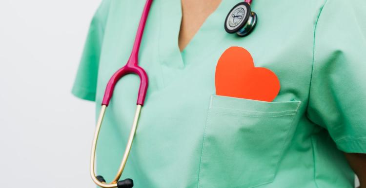 A healthcare professional with a stethoscope and red heart symbol.