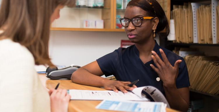 Dental receptionist talking to a customer