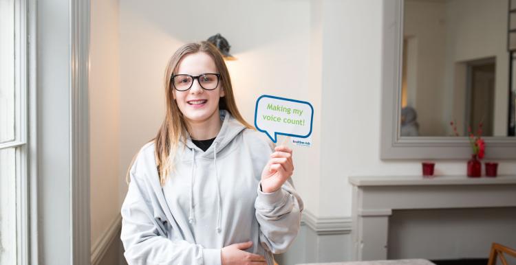 Girl holding sign saying my voice counts