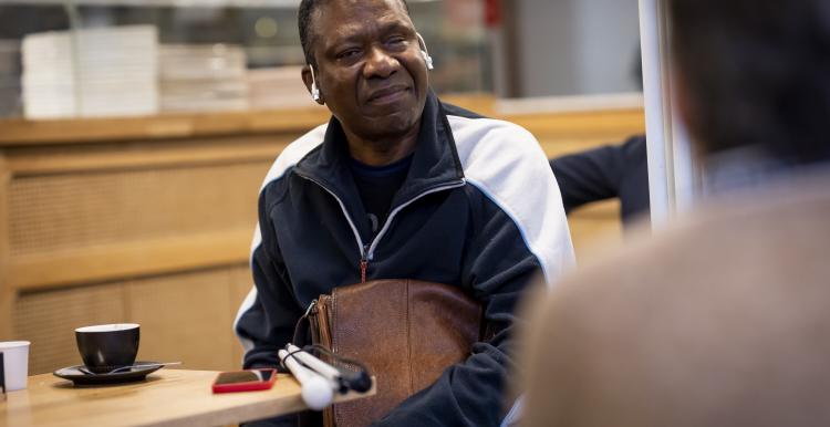 A deafblind person sitting in a cafe