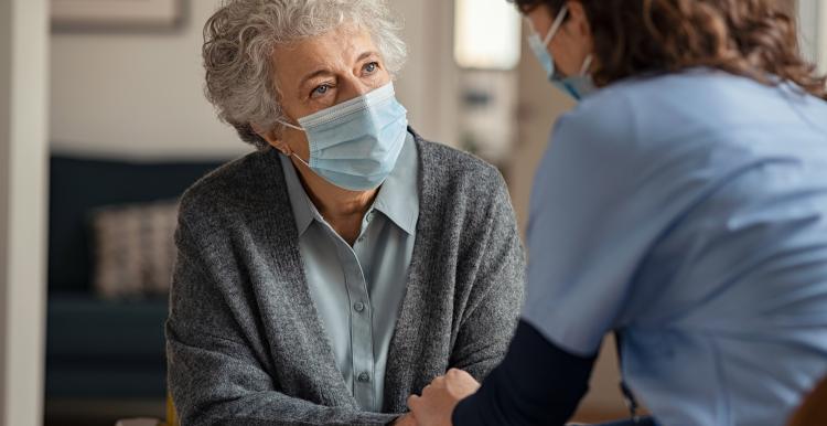 Older lady with face mask on with nurse