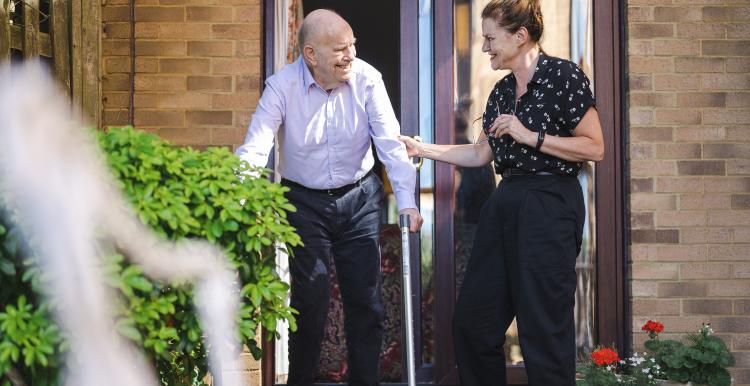 Lady helping elderly gentleman 