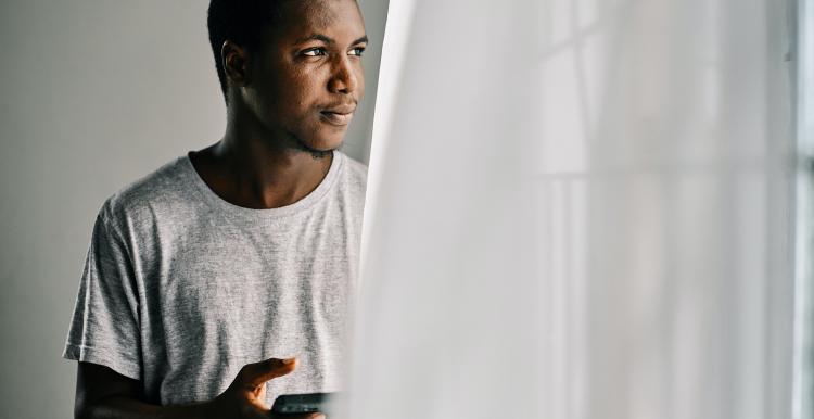 Man standing at window, looking out