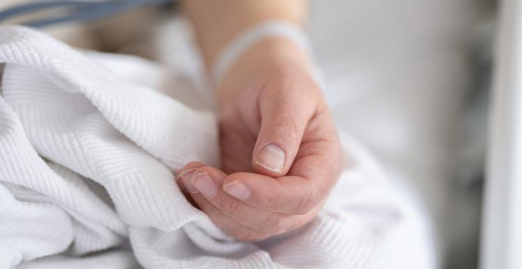 Image of an arm on bed sheets