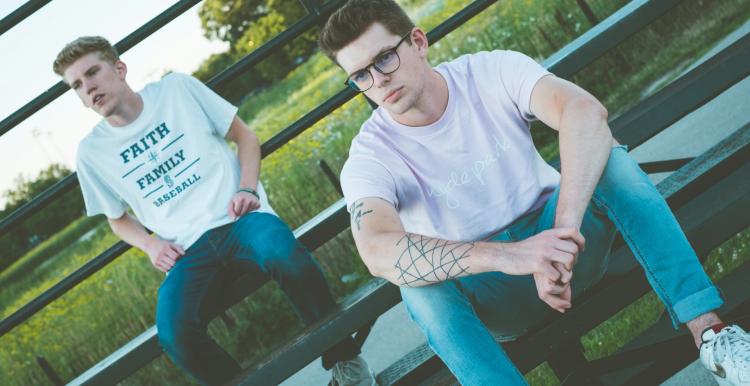 Two men sitting on benches outside