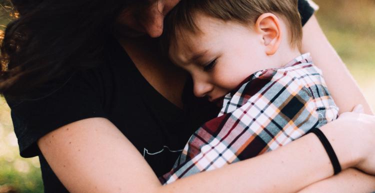 Boy in Woman's lap being hugged