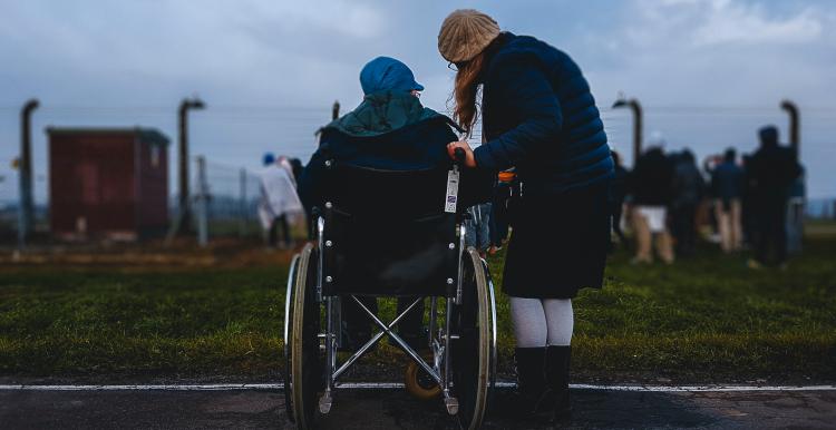 Carer supporting friend in wheelchair