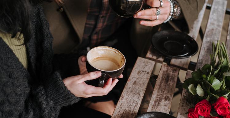 Two friends chatting with a hot coffee