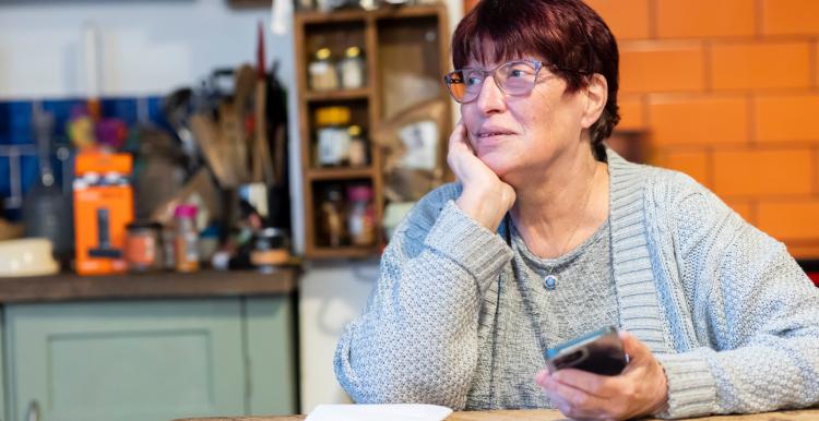 Older lady sitting at a table thinking