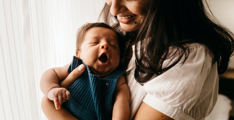 Mother and young baby cuddles