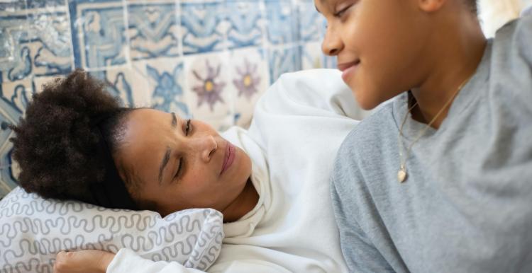 Teenager looking after her mother in her bed