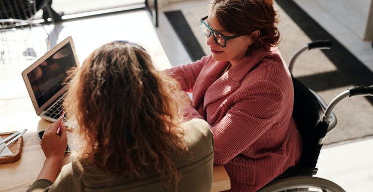Disabled lady and her carer filling in a survey on the computer