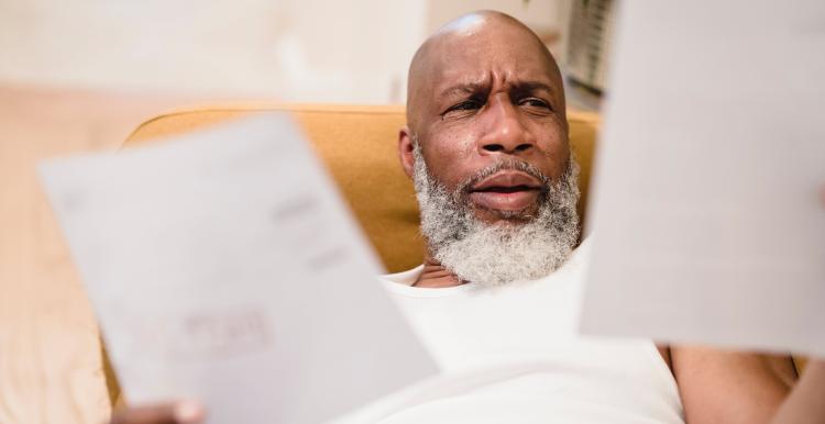 Confused male reading documents