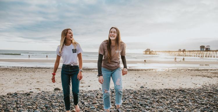 Two ladies chatting on a beach -  end loneliness 