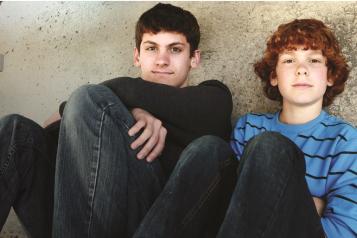 Two boys sitting down outside