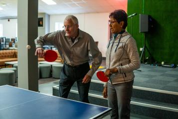 Older male and female playing table tennis