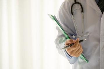 Male doctor with clipboard, pen and stethoscope 
