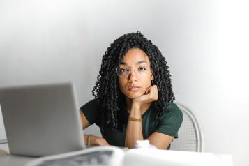 A lady sitting at her desk thinking about writing an email about her NHS complaint 