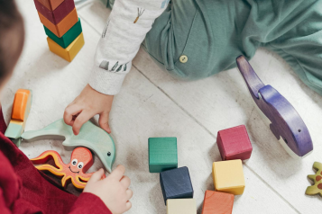 Two young children playing with wooden toys