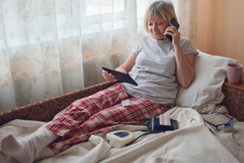 Lady laying in her bed, virtual ward.