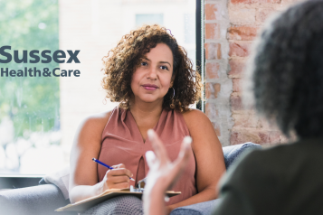 Two ladies sitting on a sofa talking about their mental health