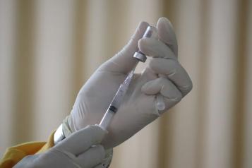 A nurse with gloves on preparing a vaccination 
