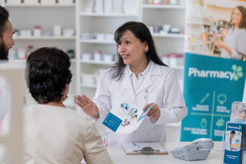 A pharmacist talking to a male and female patient 