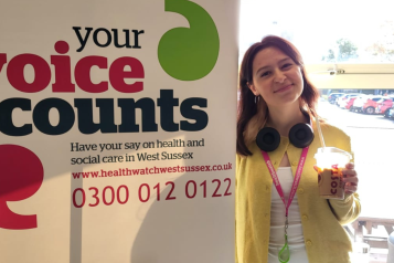 Eve, one of our student volunteers standing in front of our banner at an event 