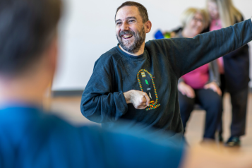 Male chair exercising with a group of other people while smiling