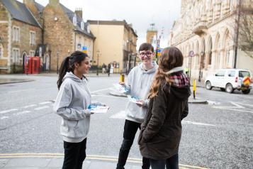 Young Healthwatch volunteers standing outside, smiling