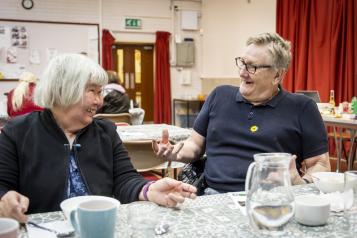 Two adults chatting at a table at an event