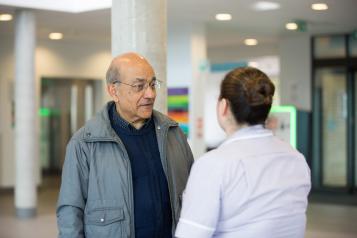 Man in hospital talking to nurse