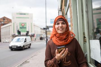 Lady smiling, holding her phone