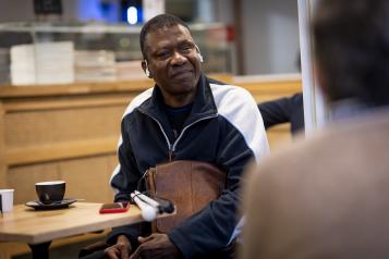 A deafblind person sitting in a cafe