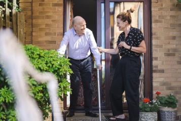 Lady helping elderly gentleman 