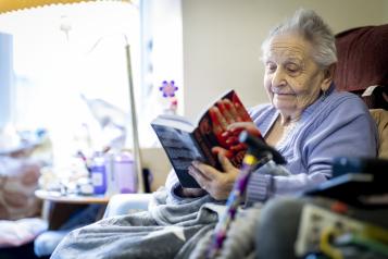 Older lady sitting in her chair reading a book