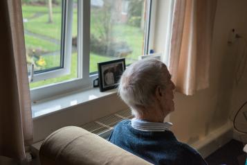 Older man looking out window. Image from Centre for Ageing Better