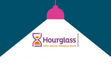 Hourglass logo under a spotlight