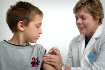 Young boy and nurse receiving flu vaccine 
